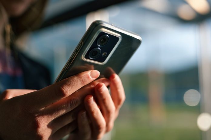 Smartphone económico en uso mostrando aplicaciones básicas en pantalla
