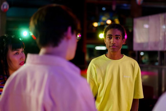 Jóvenes reunidos en ambiente nocturno urbano con luces de neón