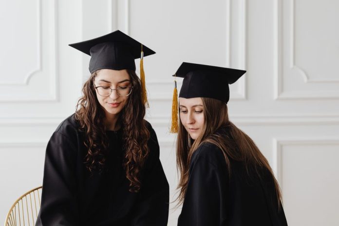 Birrete de graduación universitaria sobre escritorio con documentos académicos