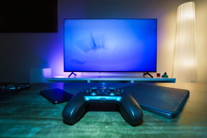 Mandos de consola y pantalla de ordenador evocando emulación de videojuegos clásicos
