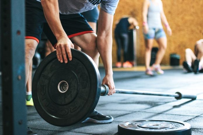 Persona mayor realizando ejercicio de fuerza en un gimnasio