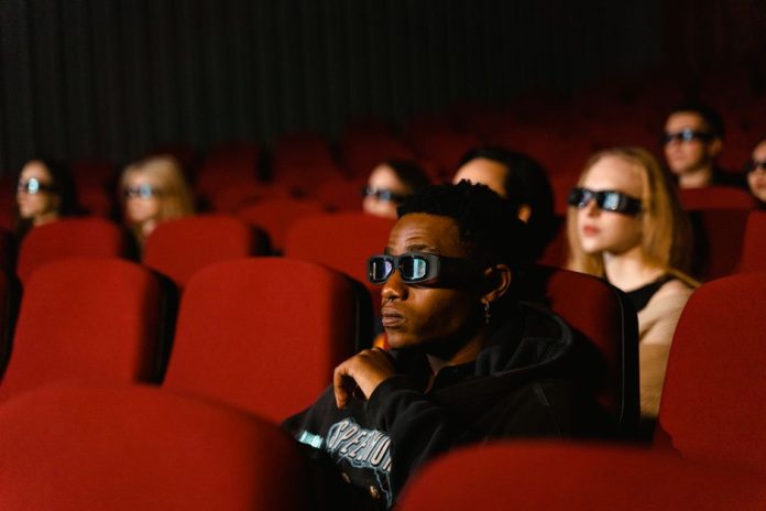 Sala de cine con pantalla iluminada y butacas vacías