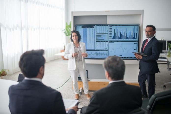 Reunión de equipo empresarial analizando datos de audiencias digitales en pantalla