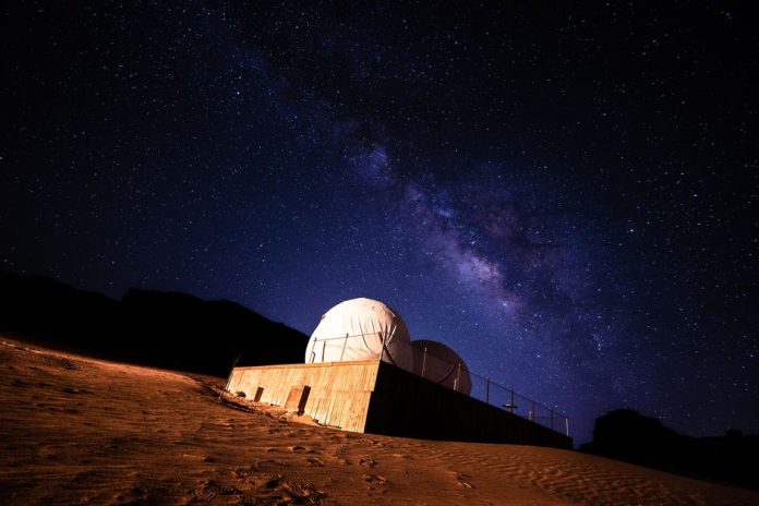 Telescopio apuntando al cielo nocturno estrellado en un observatorio astronómico