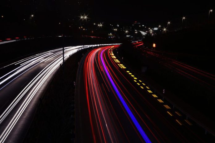 Faros de un vehículo iluminando una carretera nocturna