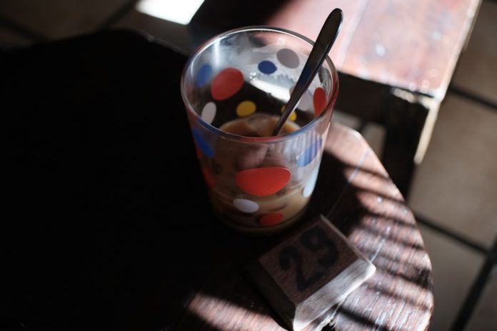 Bebida de café helada con colores vibrantes y nata montada sobre mostrador
