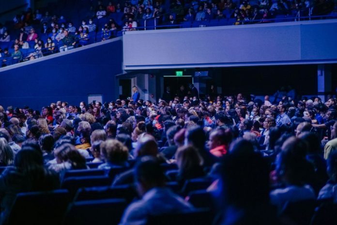 Vista general de una feria de videojuegos con público y expositores