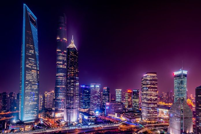 Vista nocturna de una ciudad asiática moderna con rascacielos iluminados