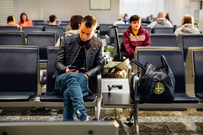 Viajero en terminal de aeropuerto con equipaje de mano