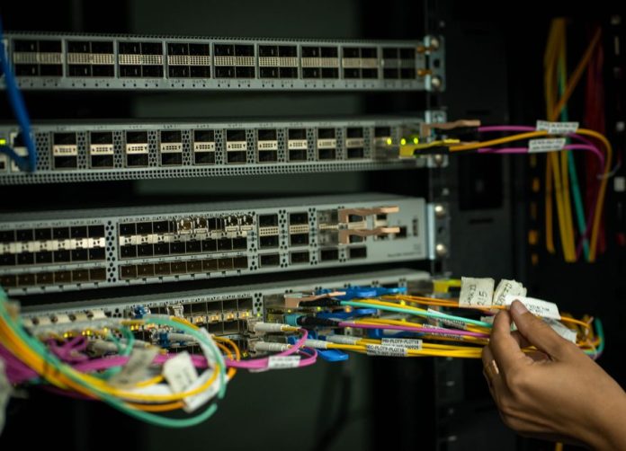 Cables de fibra óptica iluminados en un centro de datos moderno