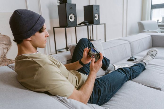 Persona jugando a videojuegos en un dispositivo móvil, símbolo del auge del gaming digital