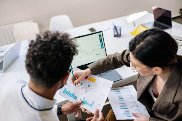 Profesional analizando datos de marketing en ordenador portátil en oficina moderna